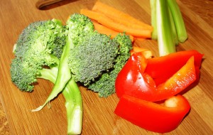 Fresh broccoli, red pepper and celery on a cutting board